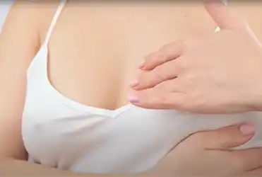 Woman giving self breast exam