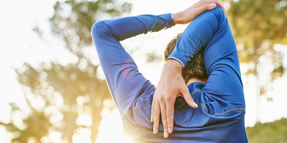 man stretching shoulders