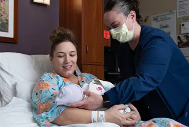 lactation consultant helping new mother learn to breast feed