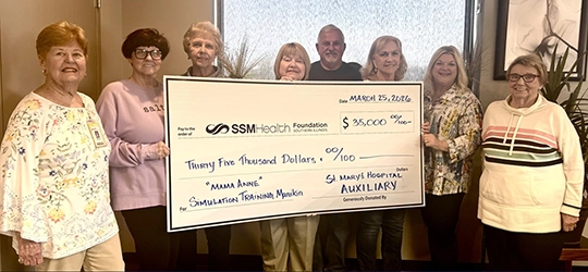 SSM Health St. Mary’s Auxiliary team holding thirty five thousand dollar check.