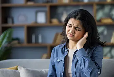 young woman holding ear in pain