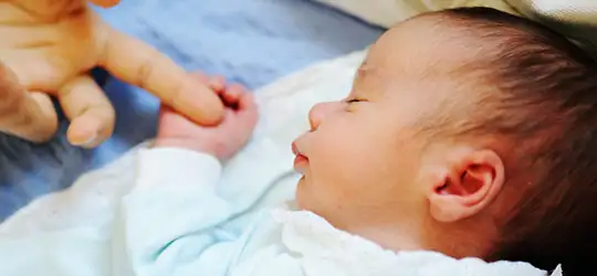 newborn holding parent's finger